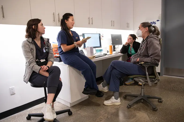 Four members of clinic staff hold a meeting in a room of the clinic