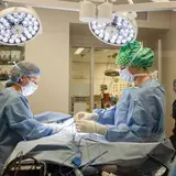 Two people in scrubs performing surgery