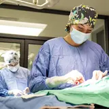 Person in scrubs performing surgery