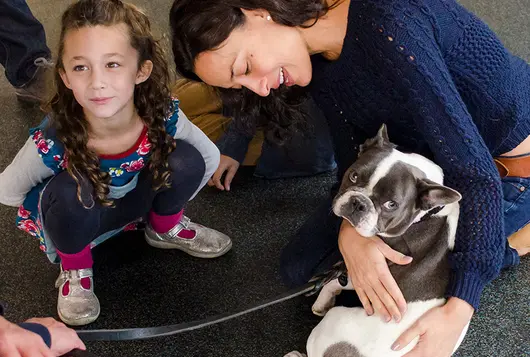 family holding dog on floor