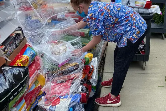 staff works to distribute pet food